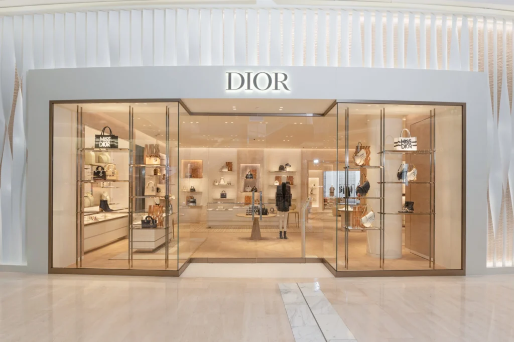Dior luxury boutique storefront displaying handbags and accessories inside a modern shopping mall – Dior 2026 collection showcase